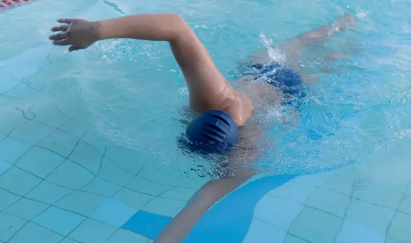 Imagem de um homem nadando em uma piscina.