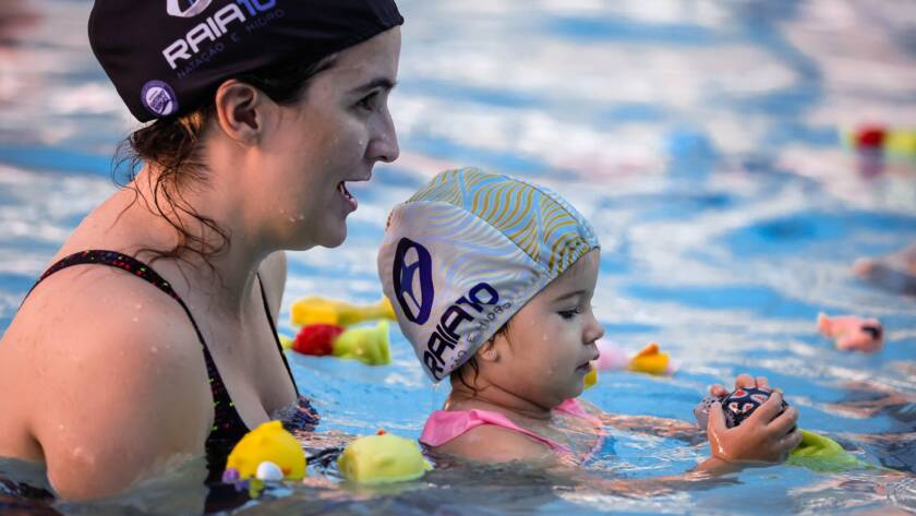 Mulher com bebê desfrutando da piscina.