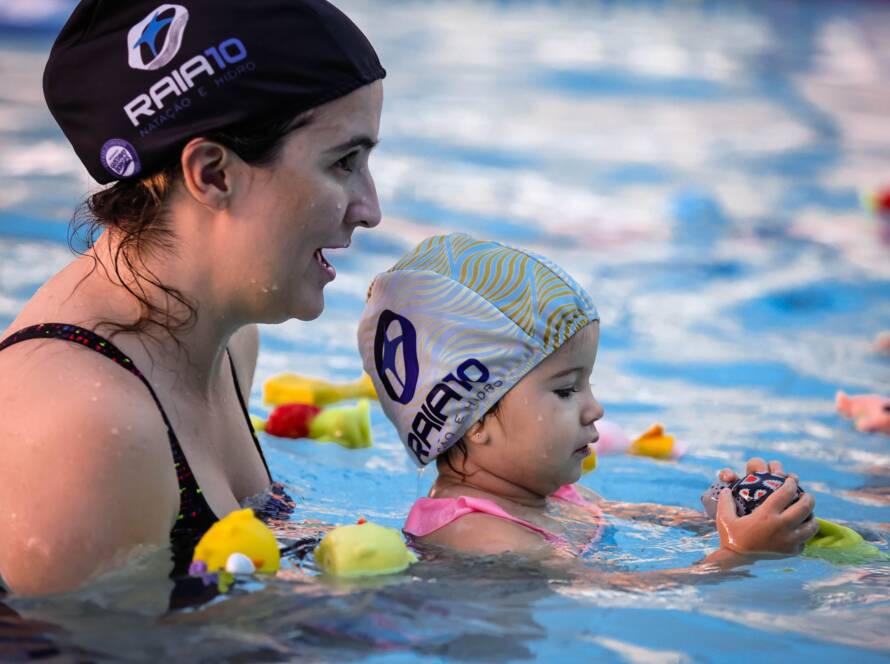 Mulher com bebê desfrutando da piscina.