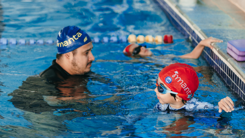 Criança sorrindo em piscina aquecida durante aula de natação no inverno em Brasília